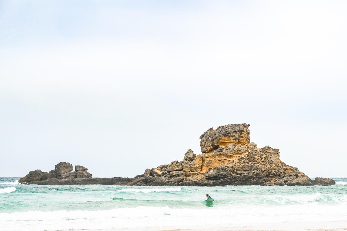 Surfeur près des rochers en Algarve