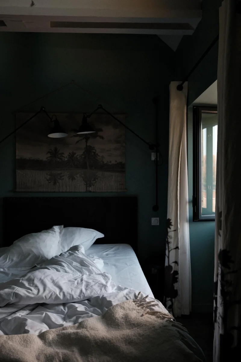 Chambre aux murs vert profond avec appliques articulées noires, Ar Duen